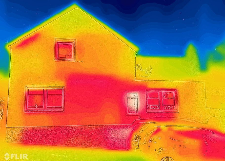 Wärmebild eines Hauses mit bunten Temperaturzonen in Rot, Gelb und Blau.